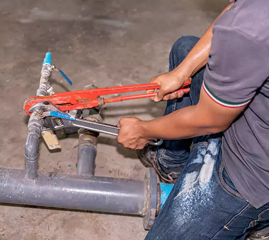 Licensed plumber repairing a copper pipe leak in a Florida basement